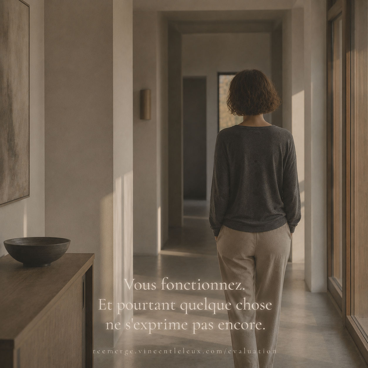 Woman seen from behind in a bright corridor, Re-Emerge
