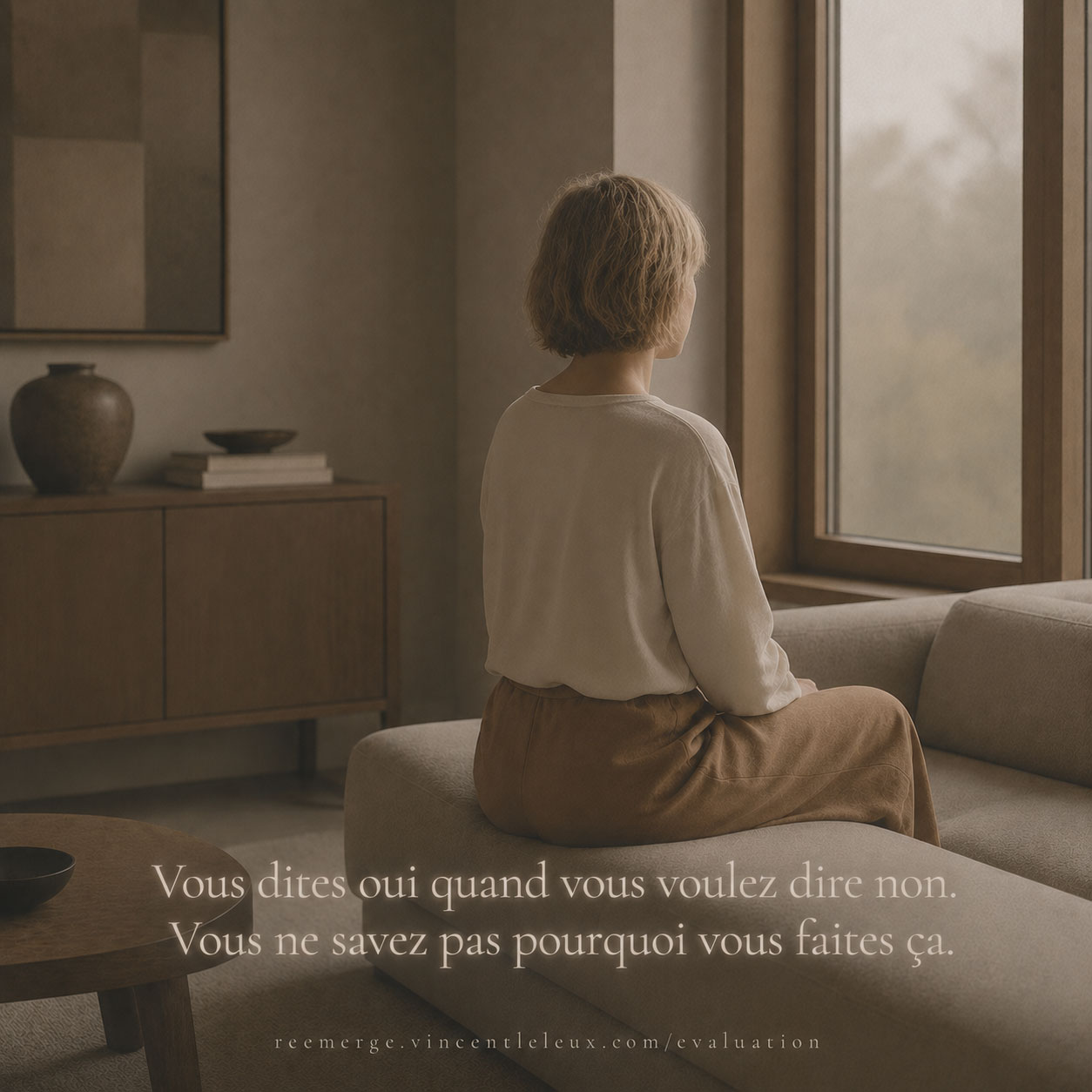 Blonde woman seated on a sofa facing a window, Re-Emerge