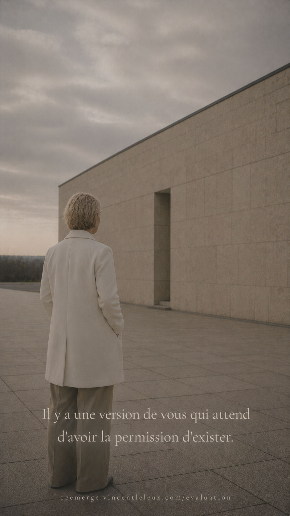 Blonde woman with short hair standing near a stone facade, Re-Emerge